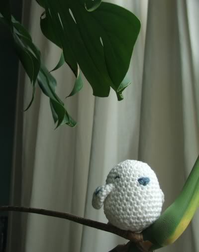 crochet bird sitting on a plant